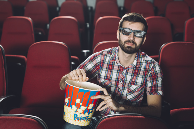 handsome-man-eating-popcorn-during-movie_23-2147803860.jpg